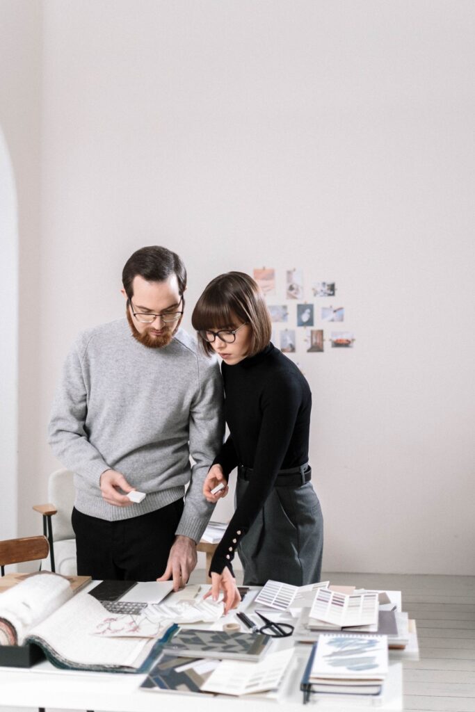 A man and woman reviewing design samples in a stylish, contemporary office space.